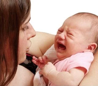 Mãe cansada com o bebê no colo
